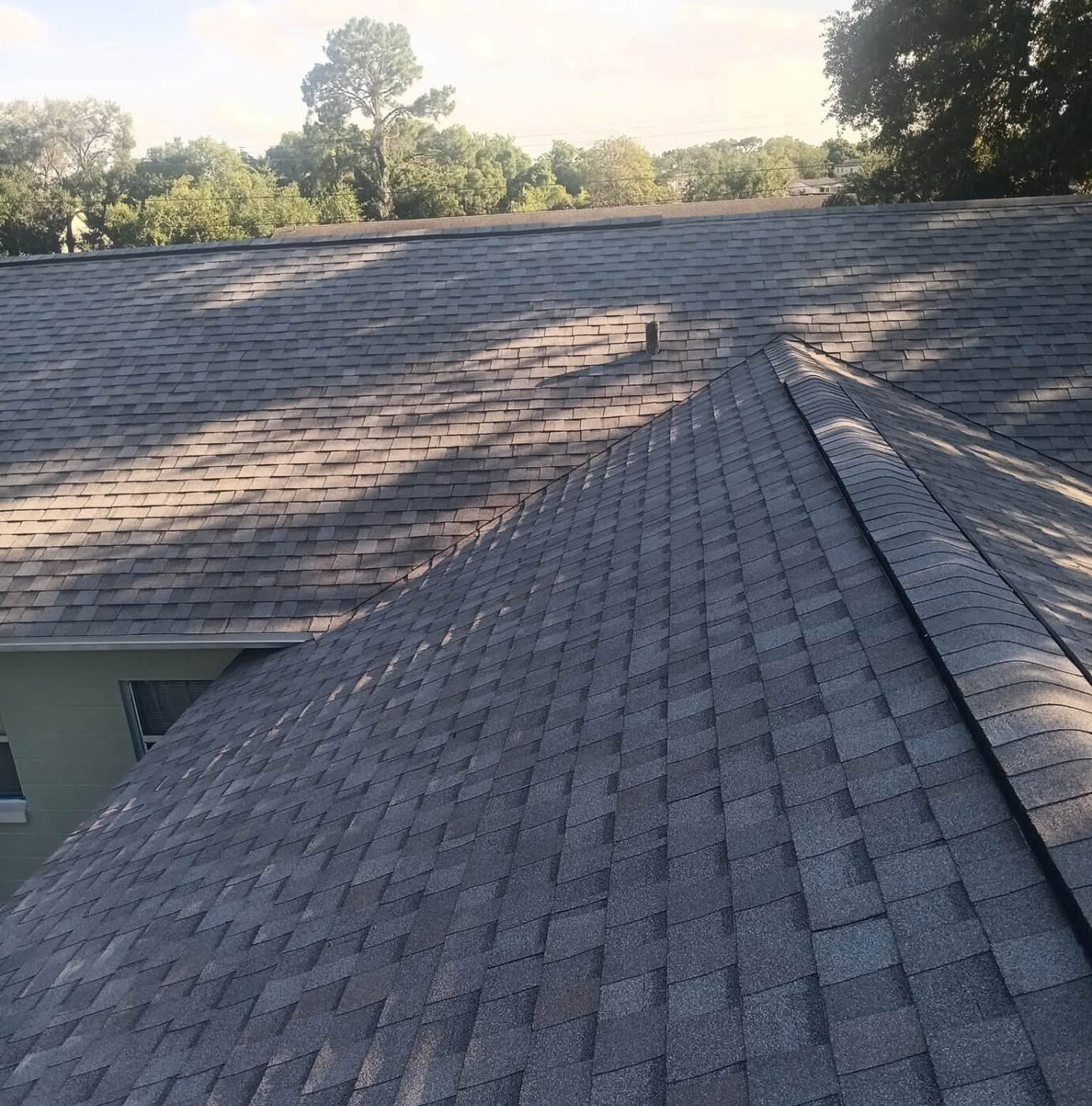 Completed brown architectural shingle roof with hip ridge cap in Seminole County