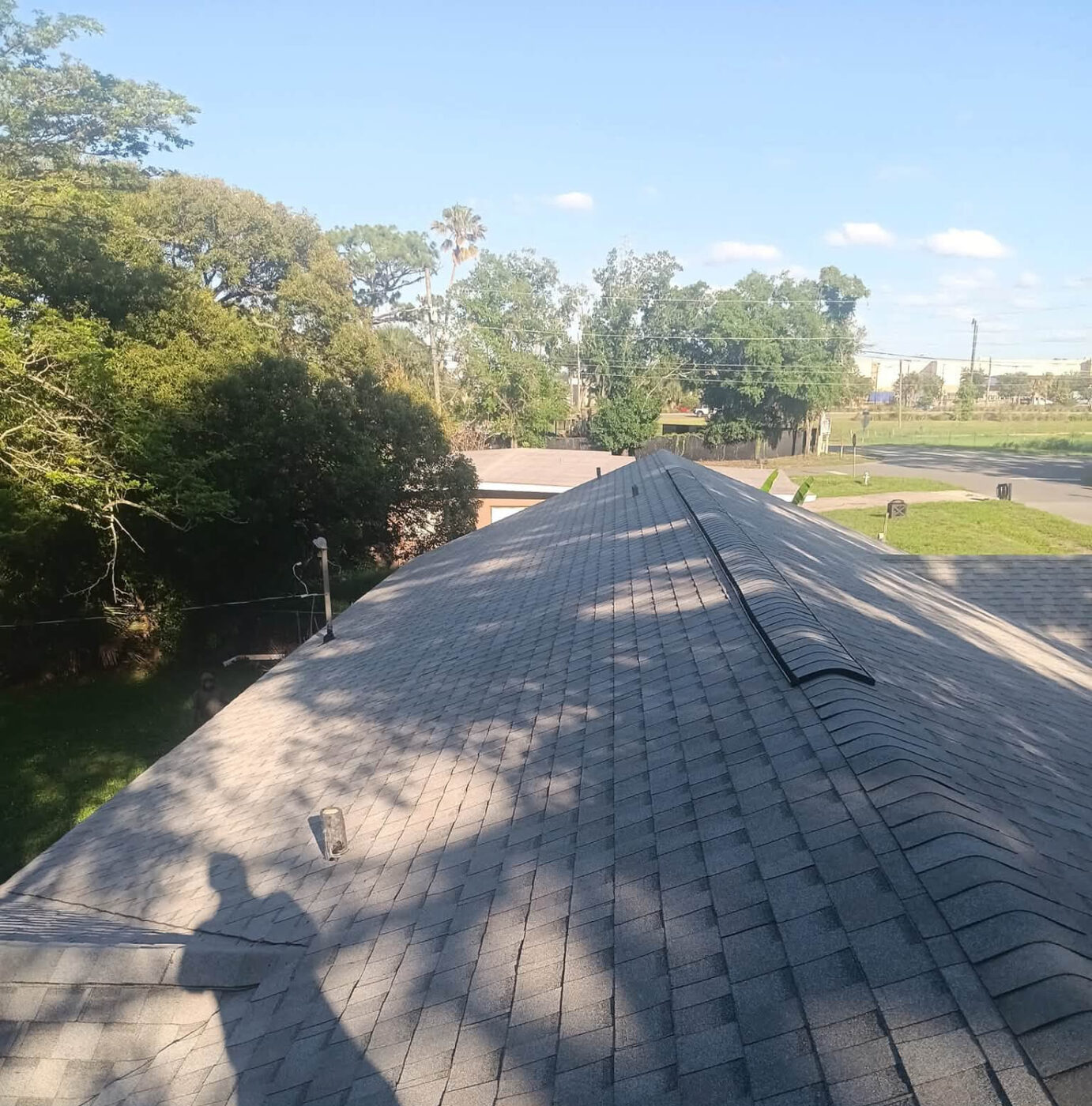 Completed shingle roof with ridge vent, viewed from the peak